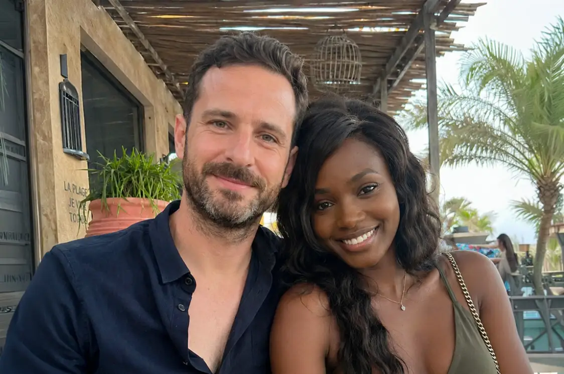 Un couple souriant sous une terrasse de bois